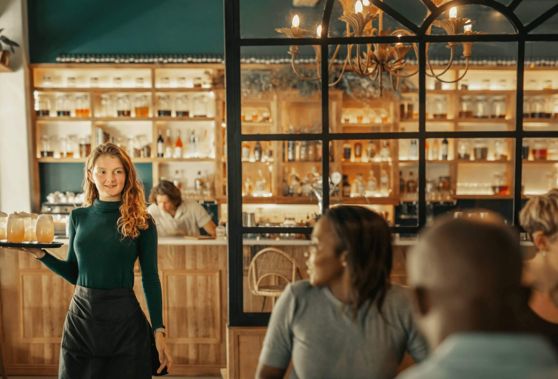 Waitress carrying drinks to table